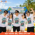 Năm thành viên mặc áo phông đồng phục nhóm slogan Đồng Nghiệp Là Cùng Nhau Tạo Nghiệp tham gia teambuilding biển