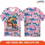 Áo phông đồng phục nhóm thiết kế màu hồng trẻ trung với hình cá mập và slogan “Nguyên Team đi chơi hết”, phù hợp cho du lịch, teambuilding và các hoạt động gắn kết tập thể.