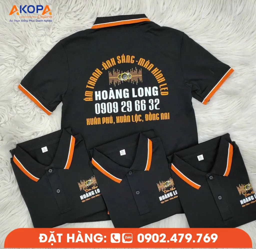 Mẫu áo polo đen phối cam tạo cảm giác năng động và nổi bật. Logo thương hiệu được in sắc nét ở ngực trái, kết hợp thông tin doanh nghiệp phía sau lưng giúp quảng bá thương hiệu hiệu quả. AKOPA nhận in áo lấy liền với nhiều màu sắc và kiểu phối theo yêu cầu.