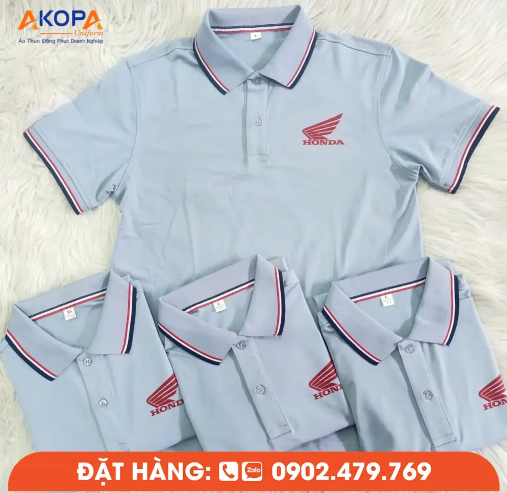 Áo polo Honda màu xanh xám được thiết kế với logo thương hiệu nổi bật ở ngực trái cùng chi tiết cổ và tay áo phối sọc đỏ xanh tạo điểm nhấn chuyên nghiệp