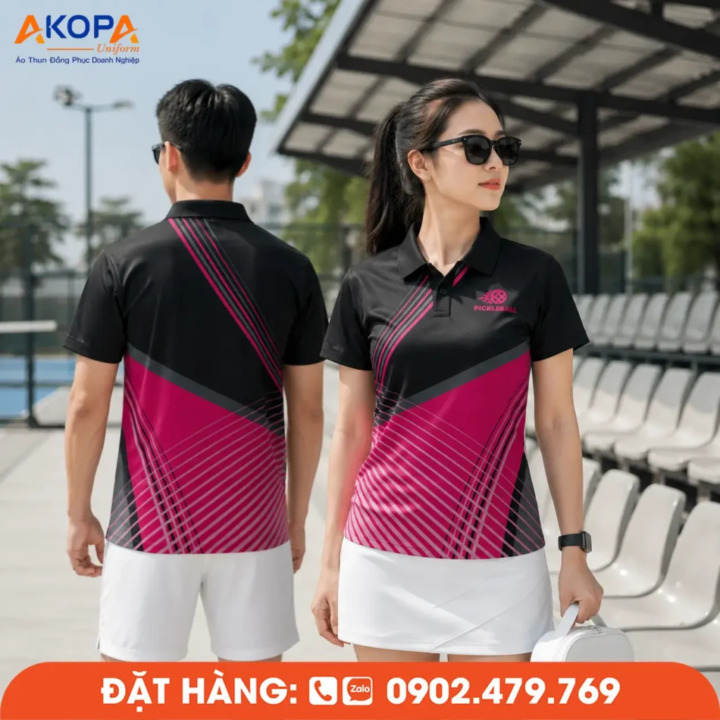 Mẫu áo Pickleball phối đen – hồng với thiết kế đường nét chéo hiện đại, mang phong cách thể thao trẻ trung và nổi bật. Chất liệu vải co giãn 4 chiều, thoáng khí, thấm hút mồ hôi nhanh, phù hợp cho thi đấu, luyện tập và đồng phục câu lạc bộ Pickleball chuyên nghiệp.