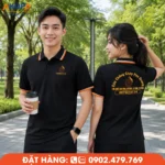 Áo polo đồng phục màu đen Phú Quang JSC nổi bật với viền cam cá tính, form áo trẻ trung và logo in rõ nét, phù hợp đội ngũ cửa hàng, kỹ thuật và dịch vụ.