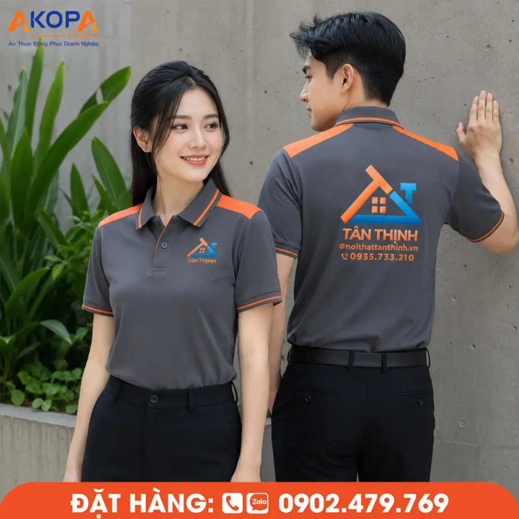 Áo polo đồng phục màu ghi phối viền cam nổi bật với thiết kế hiện đại, kết hợp logo trước ngực và in lưng sắc nét giúp tăng khả năng nhận diện thương hiệu. Mẫu áo phù hợp cho doanh nghiệp nội thất, xây dựng, kiến trúc và đội ngũ kinh doanh, mang đến hình ảnh chuyên nghiệp và năng động.