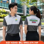 Áo polo đồng phục màu ghi phối trắng theo phong cách color block hiện đại, tạo điểm nhấn nổi bật với logo trước ngực và hình in sau lưng sắc nét. Thiết kế trẻ trung, chất liệu thoáng mát, phù hợp cho doanh nghiệp thực phẩm, dược phẩm, chăm sóc sức khỏe và đội ngũ tư vấn chuyên nghiệp.