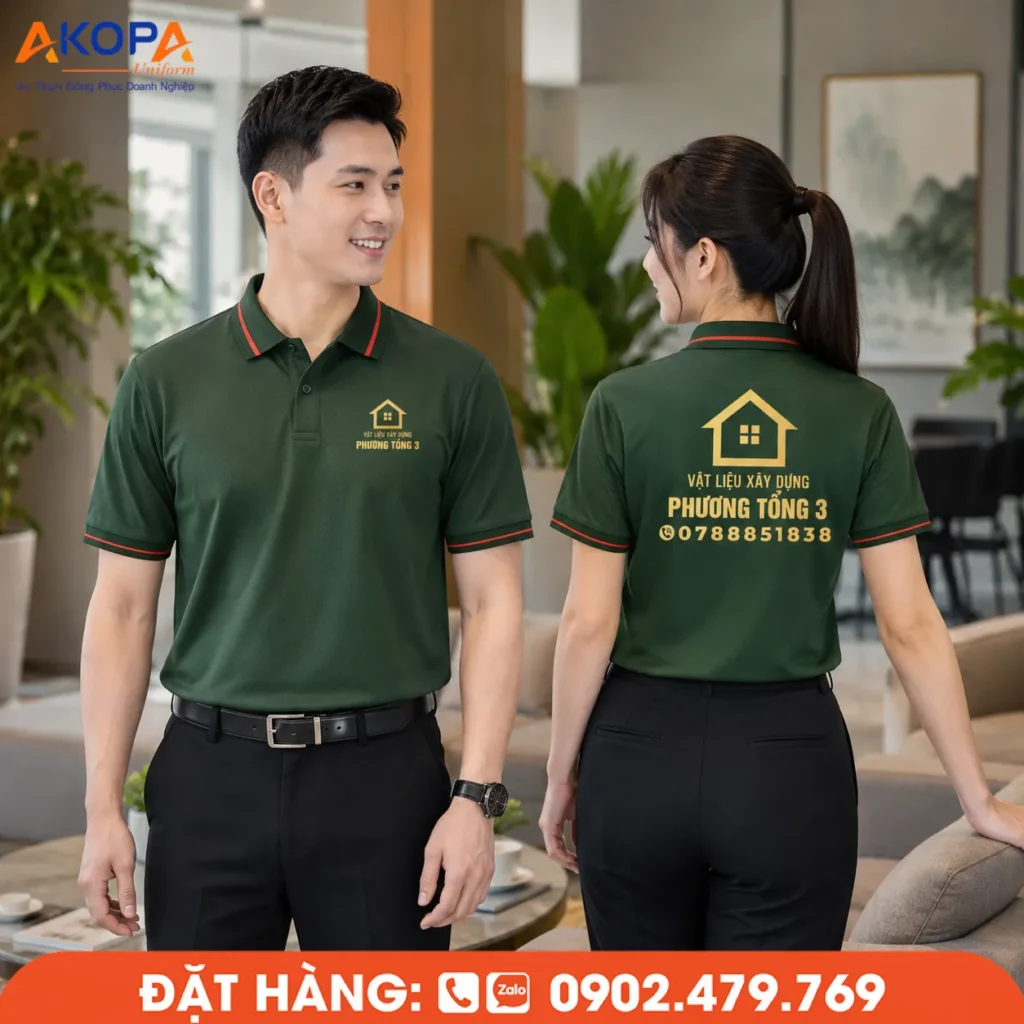 Áo polo đồng phục màu xanh rêu phối viền đỏ tinh tế, logo vàng nổi bật, phù hợp cho cửa hàng vật liệu xây dựng, showroom và đội ngũ kinh doanh.