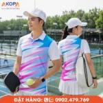 Áo đồng phục pickleball phối trắng, xanh ngọc và hồng với họa tiết chuyển màu trẻ trung, tạo điểm nhấn nổi bật, thích hợp cho đội thi đấu, câu lạc bộ và các hoạt động Pickleball ngoài trời.