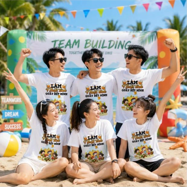 Nhóm nhân viên mặc áo phông nhóm in slogan “Làm nhiệt tình, quẩy hết mình” khi đi team building – AKOPA